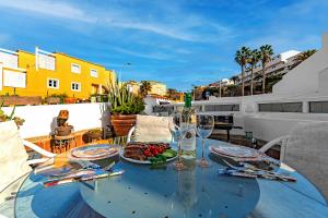 a glass table with plates of food on a balcony at Apartment on Torviscas in Adeje