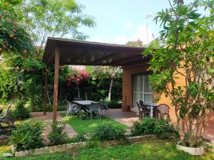 eine Terrasse mit einem Tisch und Stühlen im Garten in der Unterkunft Precioso chalet próximo a Sevilla con jardín y piscina privada 8 personas Wifi gratis 2 salones 4 dormitorios 2 baños in Consolación