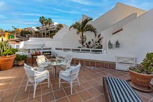 a patio with a table and chairs on a roof at Apartment on Torviscas in Adeje