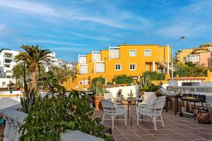 a patio with chairs and tables and buildings at Apartment on Torviscas in Adeje