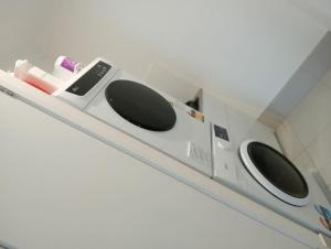 a white microwave with three knobs on a shelf at Deebing Hideaway - Harmony Haven in Loamside
