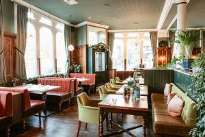 a restaurant with tables and chairs and windows at Hand & Flower in London