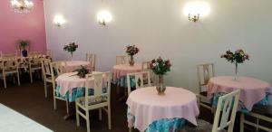 a room with tables and chairs with flowers on them at Hotel Saint Francois Xavier in Lourdes