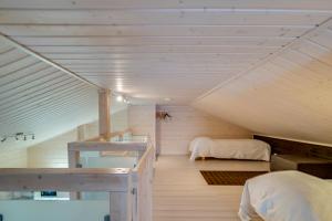 a attic room with two beds and a staircase at Rukankarhu Apartment in Ruka