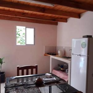 Una cocina con un refrigerador blanco y una mesa. en Alojamiento castillo dpto 4, en Curuzú Cuatiá