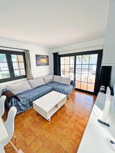 una sala de estar con un sofá y una mesa en Apartamento en la Escala con piscina y parking, en L'Escala