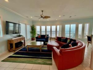 a living room with a red couch and a tv at Moonlight Sonata-Beachfront-Community Pool in St. George Island