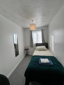 a bedroom with a bed with a green blanket at Corby Guest House in Corby +16 photos