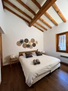 a bedroom with a large bed with white sheets and wooden ceilings at Chalet Mao in Megève
