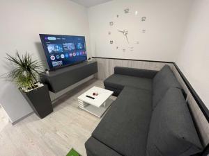 a living room with a couch and a clock on the wall at Apartment Romeo & Julija, Near terme Olimia, Free Parking, AC, Free Wifi in Podčetrtek