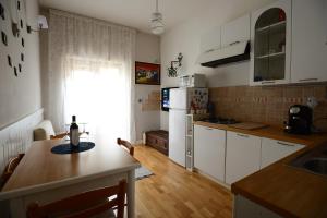 a kitchen with white cabinets and a table and a window at "Casa Verde Salvia" 2 Camere,6PAX,Wi-fi-Clima,5 min Station,Colazione,Late-check in in Rome +30 photos