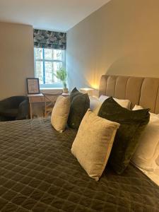 a bedroom with a large bed with pillows on it at Monsal Trail Apartment A, Bakewell in Hassop