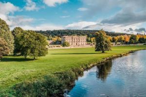 a view of a large building next to a river at Monsal Trail Apartment A, Bakewell in Hassop