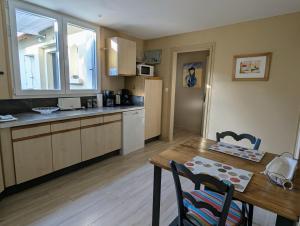 a kitchen with a wooden table and a dining room at Maison typique, centre-ville, jardin ville haute in Pornic