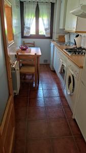a kitchen with a table and a washing machine at Apartamento LA FRAGUA in Comillas