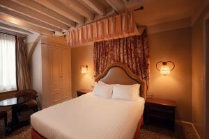 Ένα ή περισσότερα κρεβάτια σε δωμάτιο στο Hotel Odeon Saint-Germain