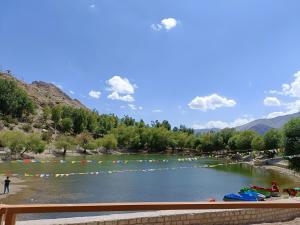 a river with a bunch of people in the water at Lakeside Nako Hotel & Restaurant in Nako