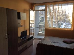 a bedroom with a bed and a large window at Marina Studio in Burgas