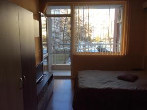 a bedroom with a bed and a large window at Marina Studio in Burgas