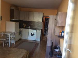 a small kitchen with a washing machine and a table at Marina Studio in Burgas