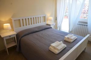 una camera da letto con un letto con due asciugamani sopra di Terrazza sul Parco a Roma