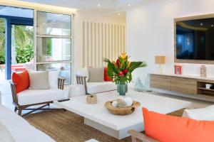 a living room with white furniture and orange pillows at Hill Rock villas - Rouge Corail in Petit-Bourg +56 photos