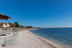 a sandy beach with umbrellas and the ocean at Bojo, No 2 in Vir