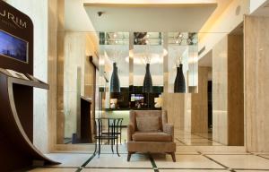a lobby with a chair and a table and vases at TURIM Restauradores Hotel in Lisbon
