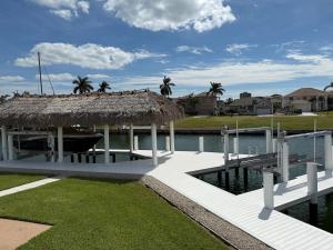 a pavilion with a thatched roof next to a body of water at Waterfront Tip Lot Treasure w/ Southern Sunshine in Henry Key
