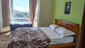 a bedroom with a bed and a large window at Dwarka Home Stay in Ooty