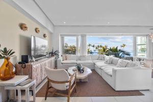 a living room with white furniture and a large window at Spectacular Apartment Ocean View Puerto Vallarta in Puerto Vallarta