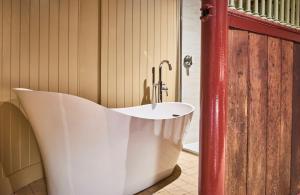 a bath tub in a bathroom with a sink at The Steed in Matfen