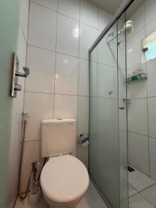 a bathroom with a toilet and a glass shower at Studio Maraba-LOFT LINDO in Marabá