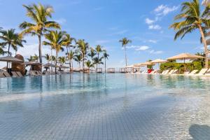 a pool at a resort with palm trees and umbrellas at Spectacular Apartment Ocean View Puerto Vallarta in Puerto Vallarta