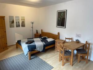 Un dormitorio con una cama, un escritorio y una mesa. en Byt v Kačení ulici, en Olomouc