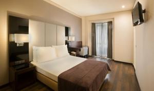 a hotel room with a large bed and a desk at TURIM Restauradores Hotel in Lisbon