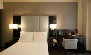 a bedroom with a bed and a desk with a laptop at TURIM Restauradores Hotel in Lisbon