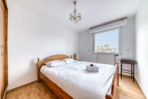 een slaapkamer met een bed en een raam bij GuestReady - Tranquil Escape in the City in La Mulatière