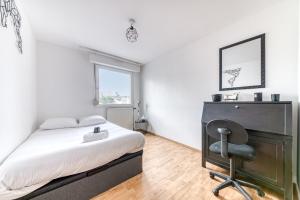 een slaapkamer met een bed, een bureau en een stoel bij GuestReady - Tranquil Escape in the City in La Mulatière
