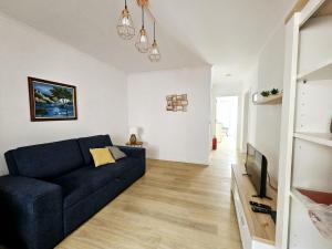 een woonkamer met een blauwe bank en een tv bij Esperança House 1 in Maia