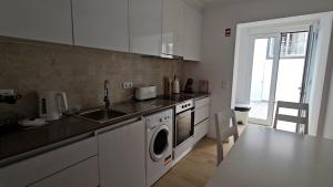 een keuken met een spoelbak en een wasmachine bij Esperança House 1 in Maia