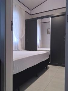 a bedroom with a large bed with a window at Recanto dos pássaros in Penha