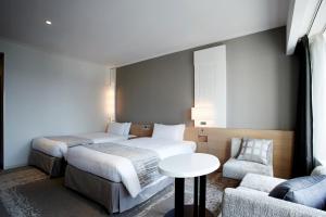 a hotel room with two beds and a table and a couch at Keio Plaza Hotel Tokyo in Tokyo