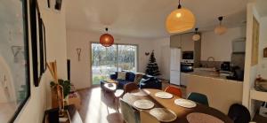 a kitchen and a living room with a table and chairs at La Villa Rivière & SPA in Saint-Laurent-de-Médoc