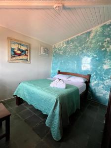 ブジオスにあるPousada Nomades Buziosの壁に絵が飾られたベッドのある寝室