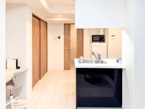 a white kitchen with a sink and a desk at Triphome Tokyo Sugamo 2024 New 3 mins 2 stations in Tokyo +49 photos