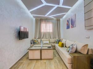 a living room with a couch and a table at Sublime appartement moderne in Agadir
