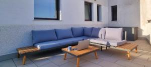 eine blaue Couch auf einer Terrasse mit einem Tisch und einem Laptop in der Unterkunft PREMIUM Magníficas Vistas Panorámicas con Terraza - By Aloha Palma in Águilas