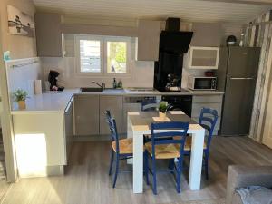 a kitchen with a table and chairs in a kitchen at Chalet T3 15 min plage grande terasse et piscine in La Teste-de-Buch
