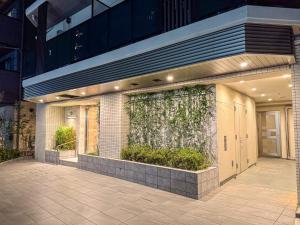 a building with a wall with plants on it at Triphome Tokyo Sugamo 2024 New 3 mins 2 stations in Tokyo